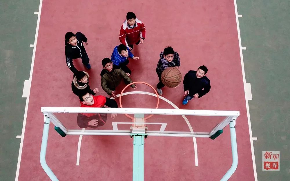 1月23日，在南通虹桥二中，孙建军（右一）和同学们一起打篮球。    新华社记者 季春鹏 摄