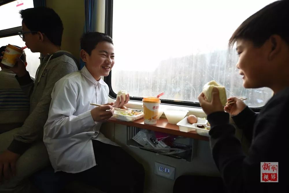 2月2日，孙建军（中）在K419次列车上吃早饭。  新华社记者 韩瑜庆 摄