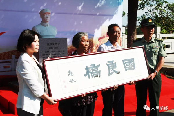 驻军代表为沈国良烈士父母赠送牌匾。
