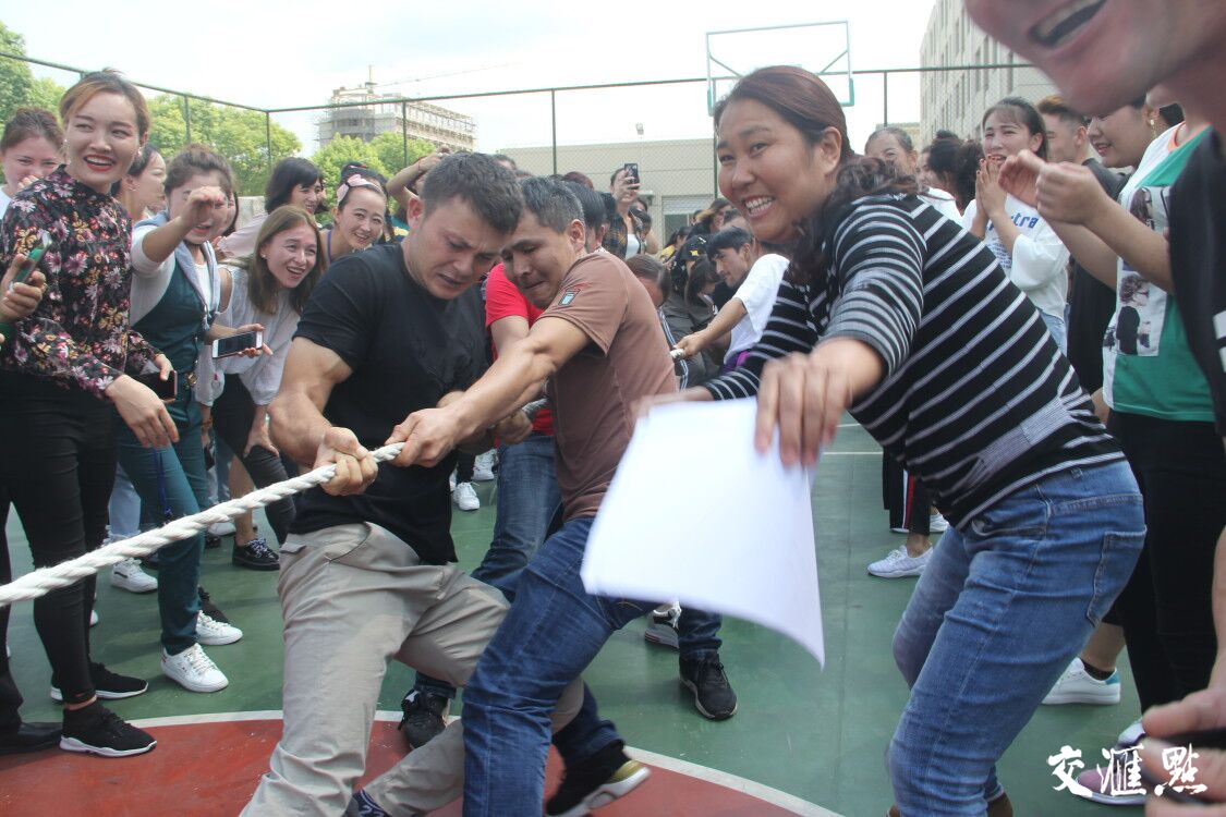 图四 杨雪莲（右一）组织新疆员工开展拔河比赛。（资料图）