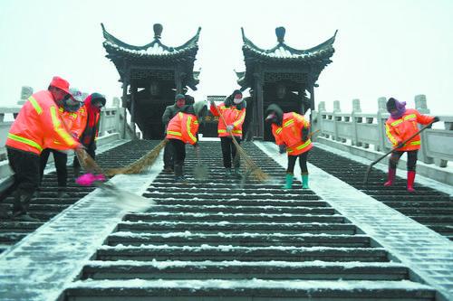 一组环卫工人在淮安里运河常盈桥上清扫台阶积雪。  桂宝林 摄 视觉江苏网供图 