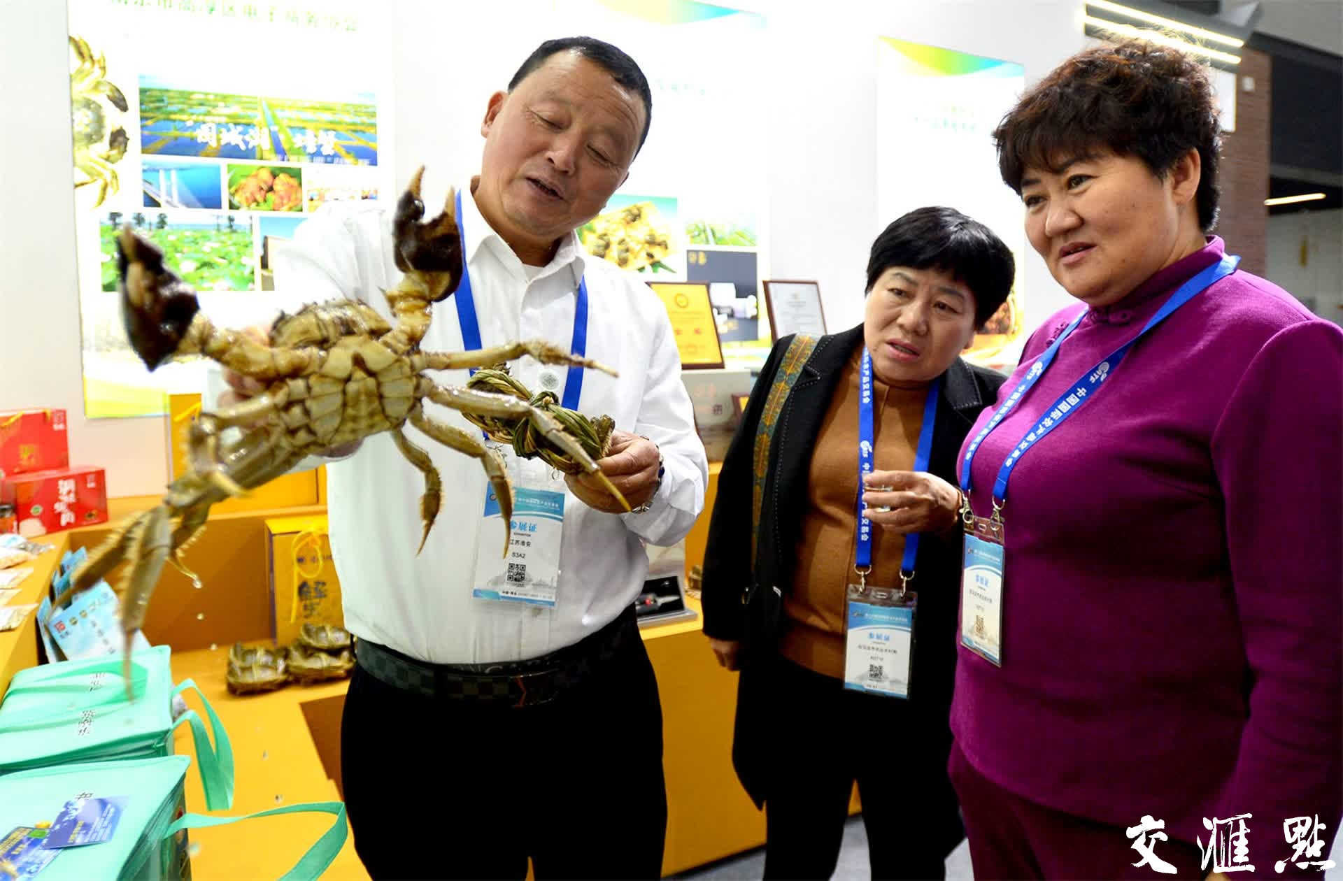 11月9日,在农交会江苏展区,一位参展商向观众展示养殖的洪泽湖大闸蟹。