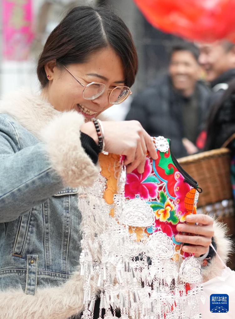 1月18日,顾客在湖南省凤凰县山江镇集市上选购苗族银饰。春节临近,神州大地年味渐浓。新华社记者 薛宇舸 摄
