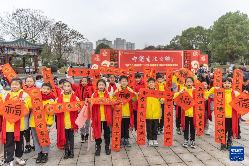 1月18日,重庆市永川区举办“书香永川·墨香万家”为主题的新春送万福进万家活动,组织当地书法家、民间文艺家及部分学校师生现场书写春联、写福字、做剪纸,并将其免费赠送给广大市民。这是小朋友展示领取的春联。春节临近,神州大地年味渐浓。新华社记者 黄伟 摄