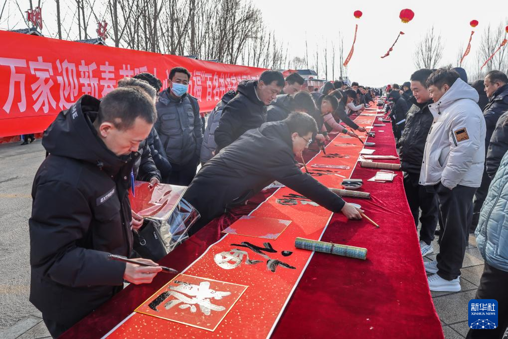 1月18日,在山东省淄博市高青县举行的山东乡村文化旅游节启动仪式现场,书法爱好者为居民写福字。春节临近,神州大地年味渐浓。新华社记者 朱峥 摄