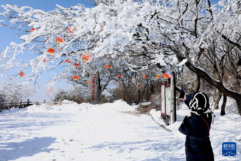 2月25日,游人在江苏省连云港市花果山玉女峰拍摄雪景。新华社发(王春摄)