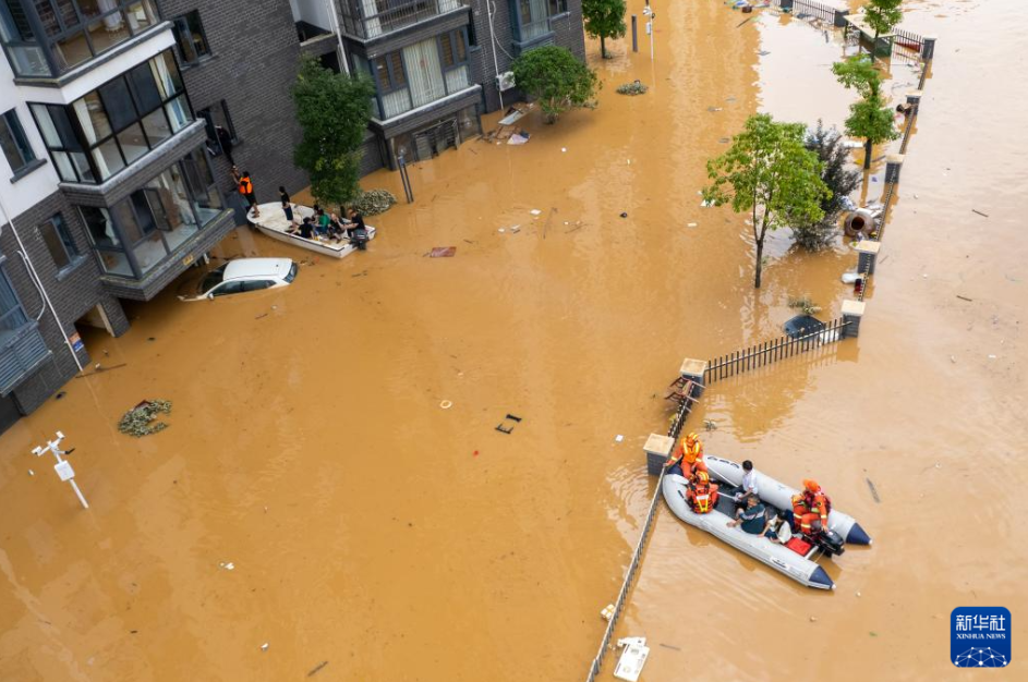 7月2日,在平江县大桥西路附近,消防员在转移群众(无人机照片)。