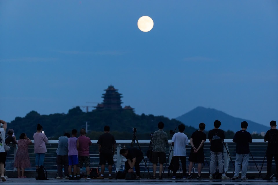 9月17日晚,在南京拍摄的中秋月,阅江楼与月亮相映成景,很多市民来到扬子江生态公园“T台水梦”景点休闲赏月。 新华日报·交汇点记者 蒋文超 摄