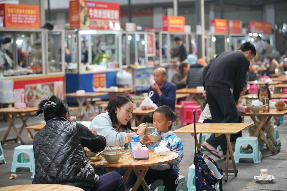 3月29日,人们在云南瑞丽一处综合农贸市场吃早点。