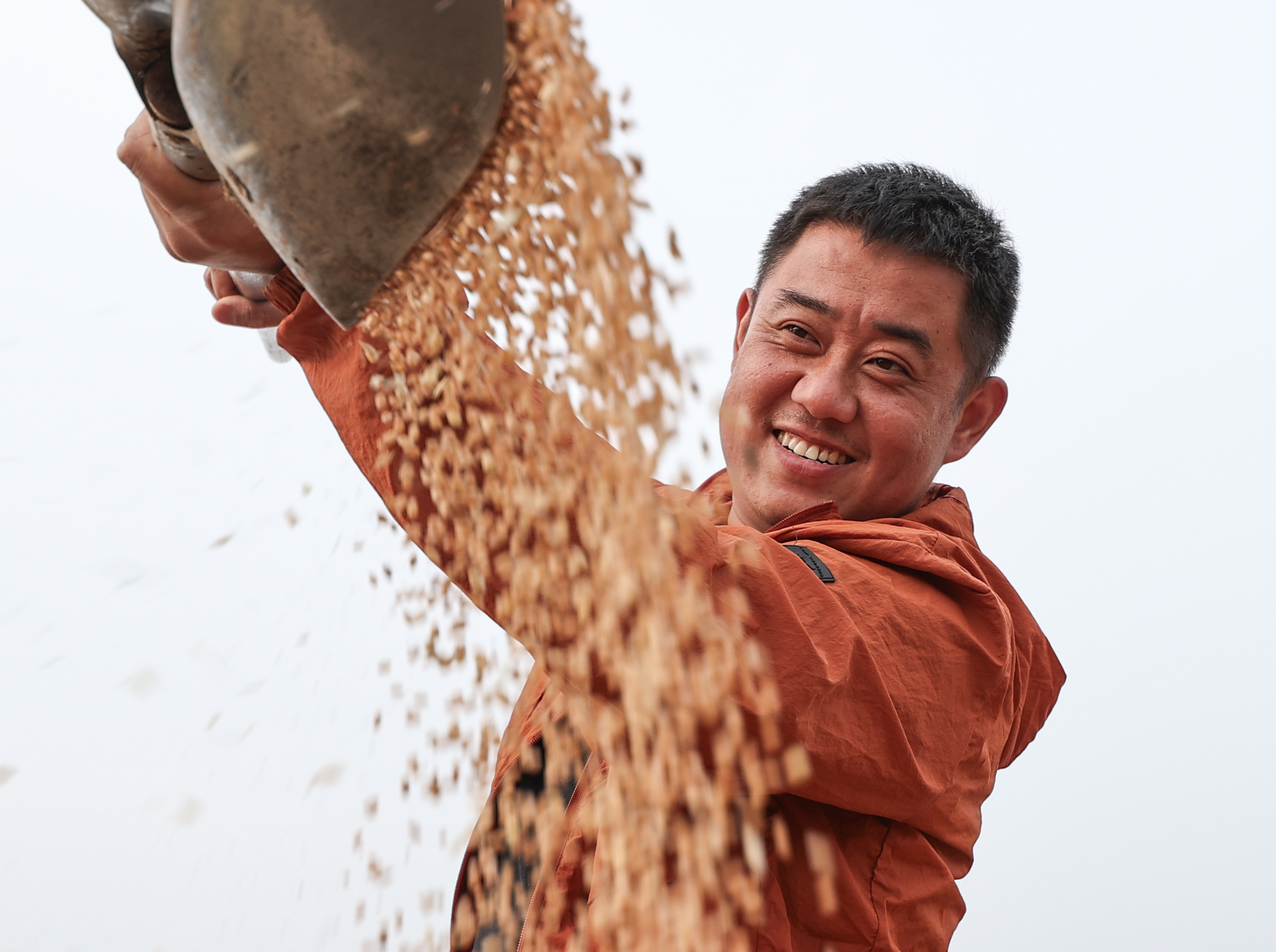 5月27日,盱眙县种粮大户刘凯在田间查看收获的小麦。许昌银 摄