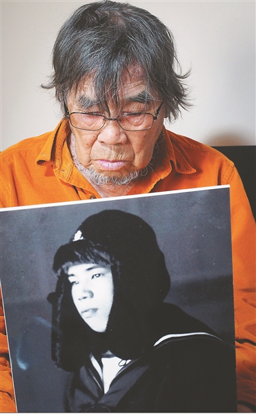 侵华日军原士兵三谷翔手捧自己当年的照片,在沉默中忏悔. 余 萍摄
