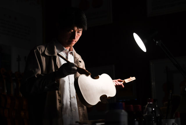江苏省工匠,高级技师,企业首席制琴师徐小峰在工作室里对小提琴白坯