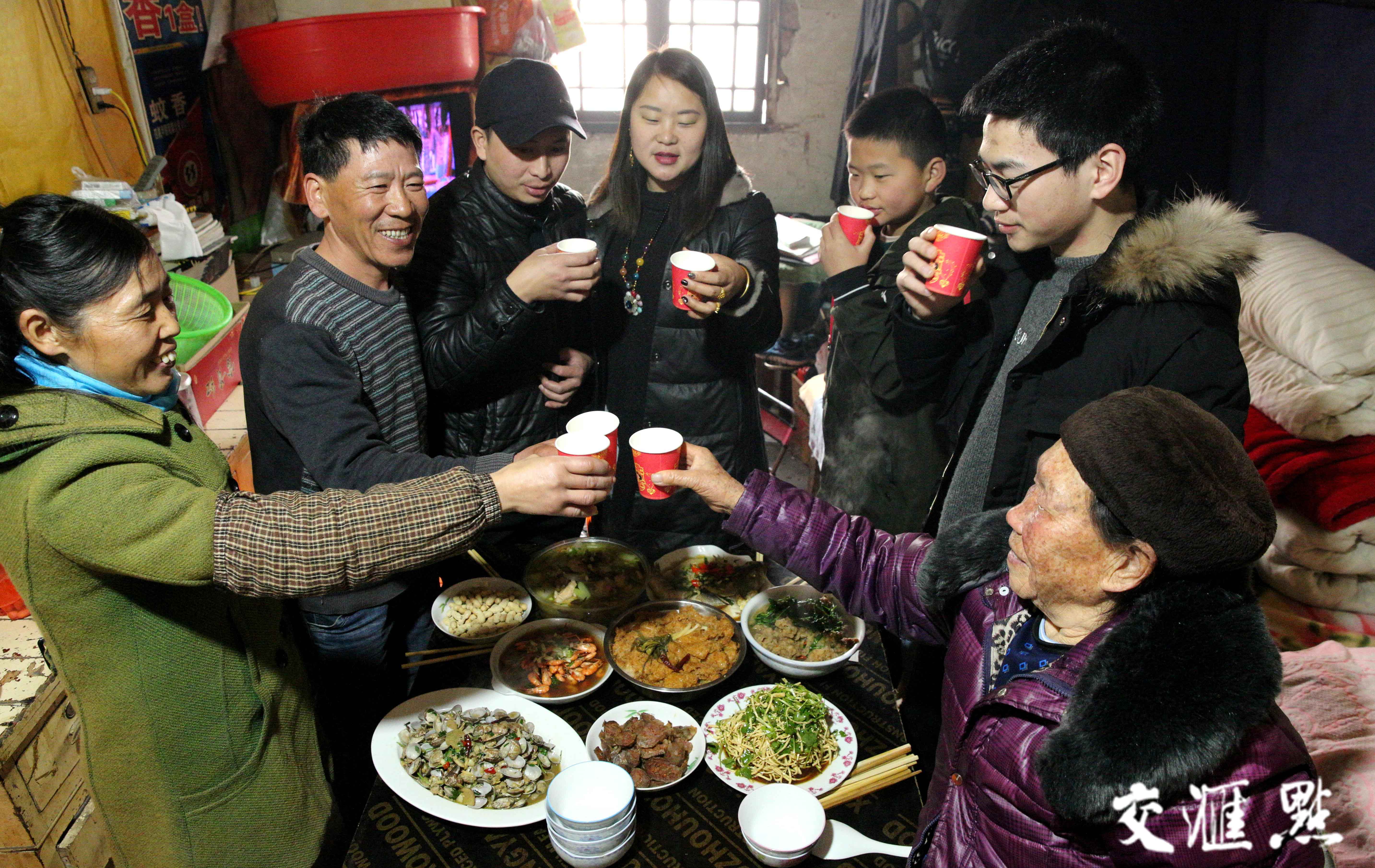 一家人围坐在桌子旁,桌子上摆满了地道的家常菜