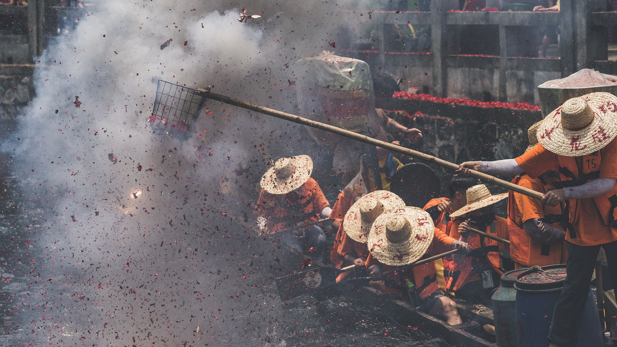 广州,龙舟上的村民正在用篮子放鞭炮.