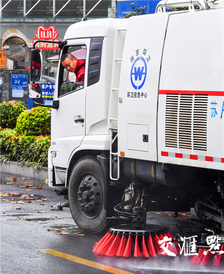 21日一大早，南京大风降温导致满地落叶，南京市环境卫生保障应急处置中心的党员李文莱第一时间出车上路开展清洁工作。杨康 摄