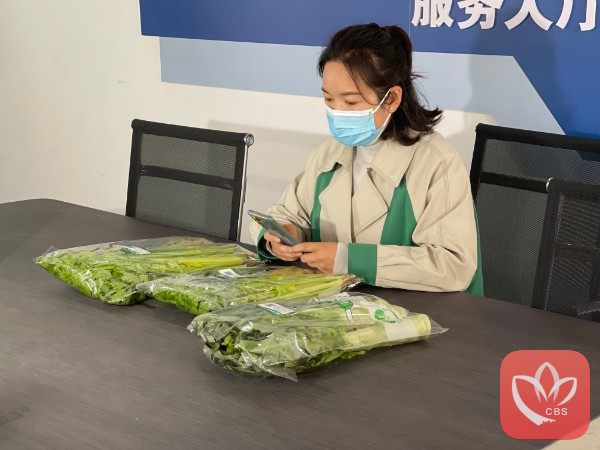 市民扫描蔬菜包装上的二维码。