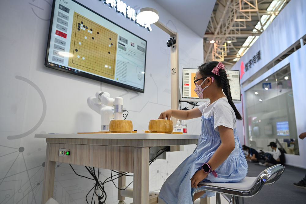 7月22日，小朋友在第五届数字中国建设成果展览会上和AI机器人下棋。新华社记者 周义 摄