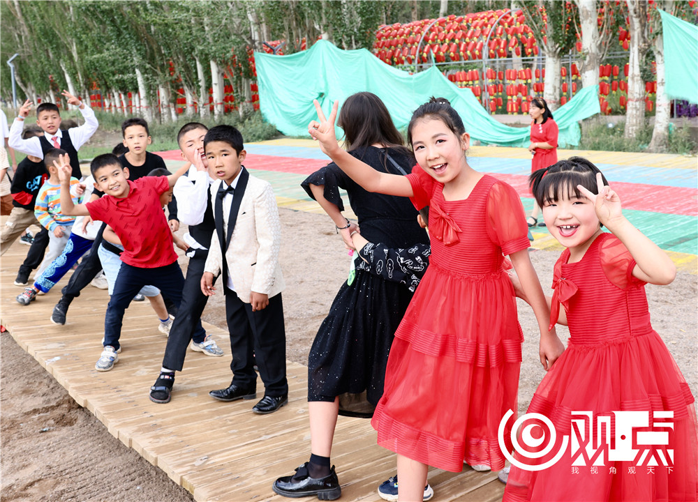 游客在乌恰县百杏生态园内开心游玩。该园集“赏、吃、住、行、游、购、娱”为一体，为乡村旅游精准扶贫项目。