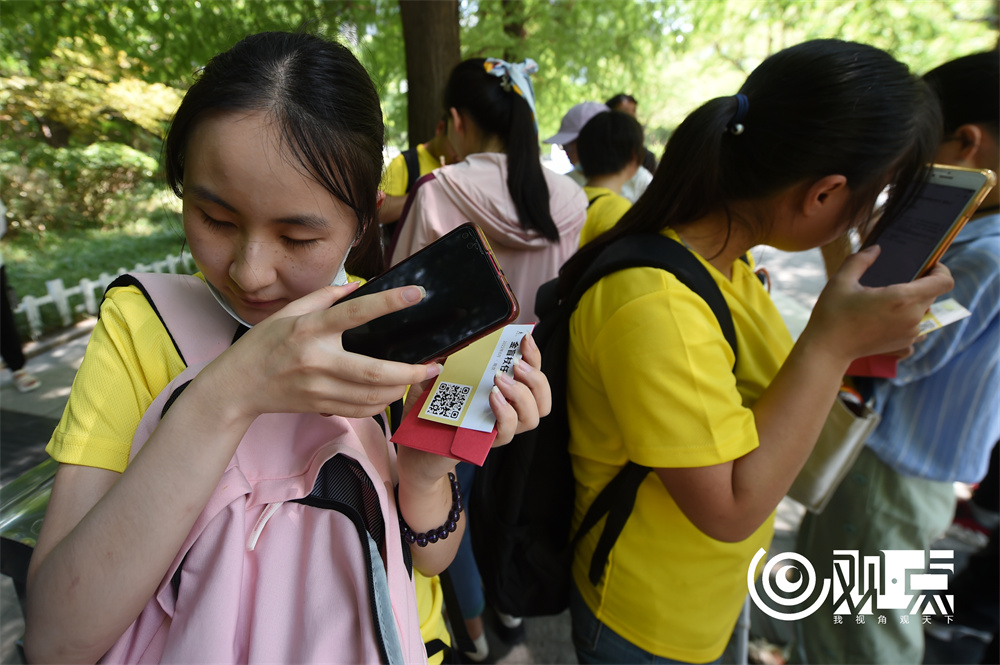 肖铮等人正在抽签、扫二维码、听出行目的地。