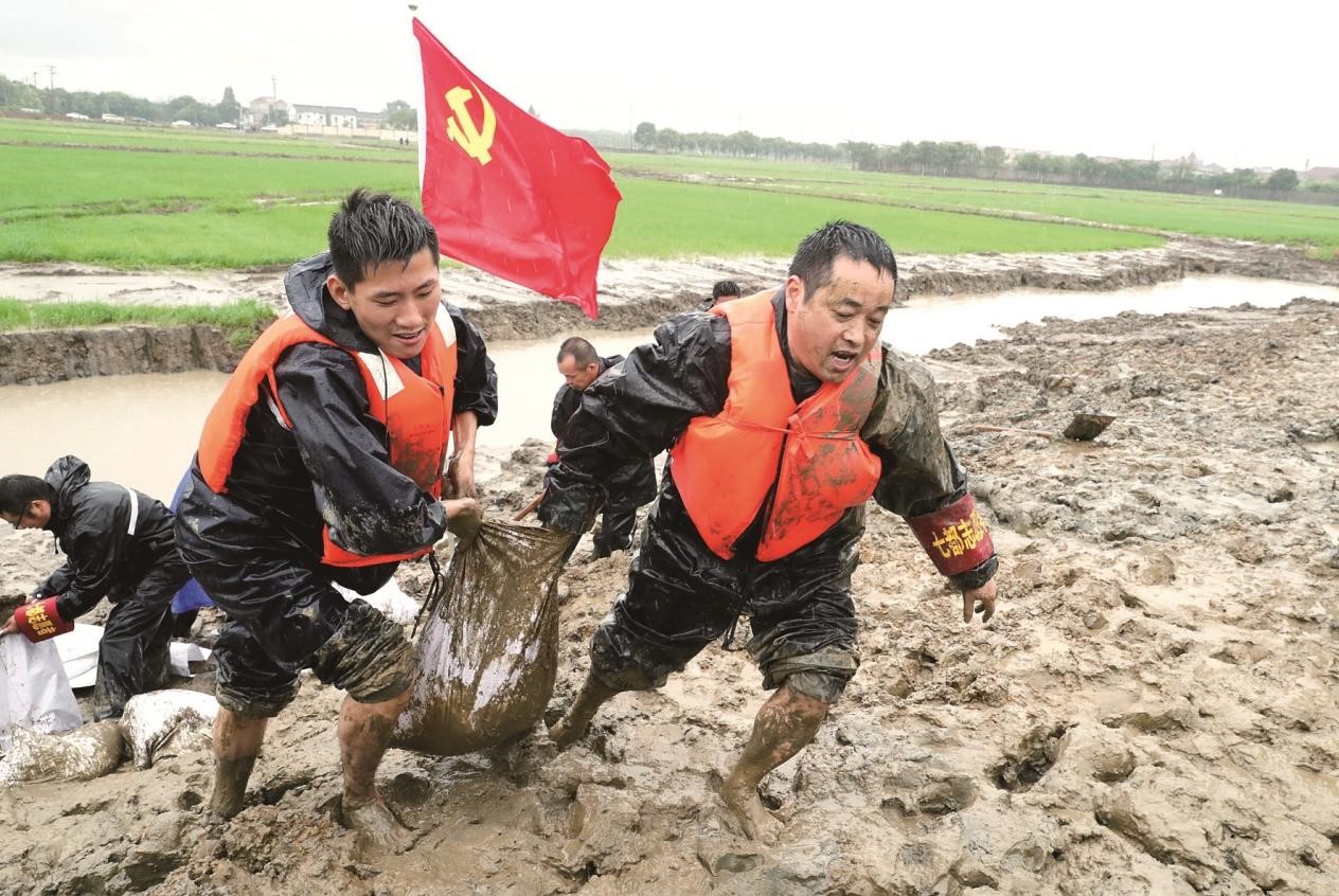 2020年7月，苏州吴江区七都镇的抗洪救灾党员突击队员们正在太湖内河加固堤坝。