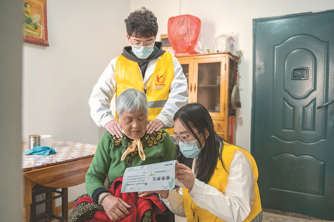 南京中医药大学养老服务与管理学院“时间银行”志愿队成员上门服务老人。 （受访者供图）