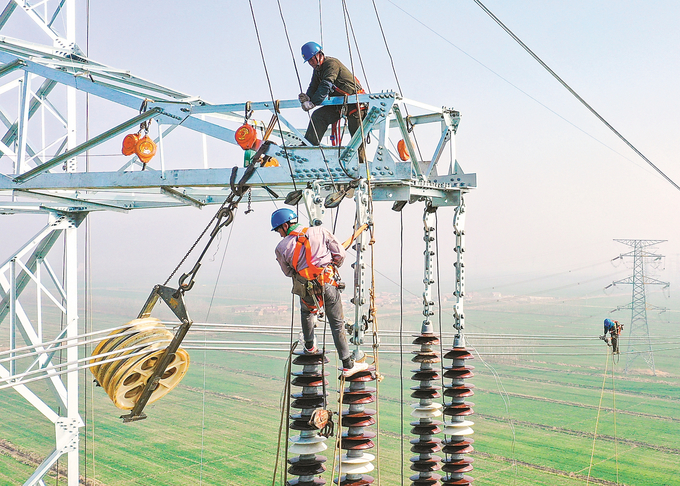 3月9日，連雲港田灣核電500千伏送出加強工程現場，施工人員搶抓晴好天氣在70米高空架設導線。 史俊 攝 （視覺江蘇網供圖）