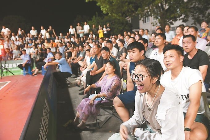 每晚两场比赛，常州横山桥镇新安村健身广场吸引众多村民和暑假中的孩子前来观战。记者 余萍/摄