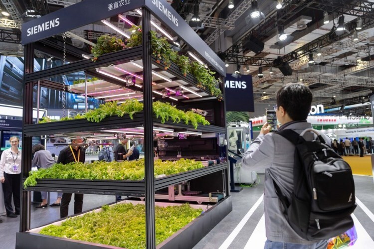 A visitor takes photos at the booth of Siemens at the 6th China International Import Expo (CIIE) in east China's Shanghai, Nov. 9, 2023. (Xinhua/Wang Xiang)
