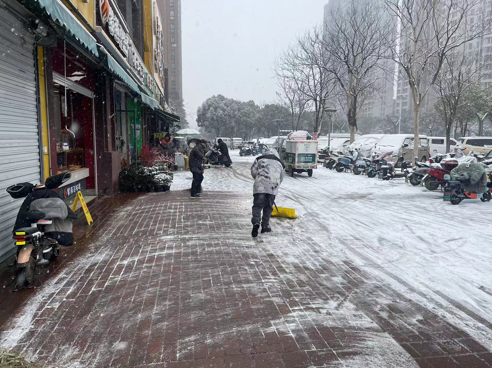 栖霞区金尧花园小区居民夏国利和家人积极参与扫雪工作,为小区居民在