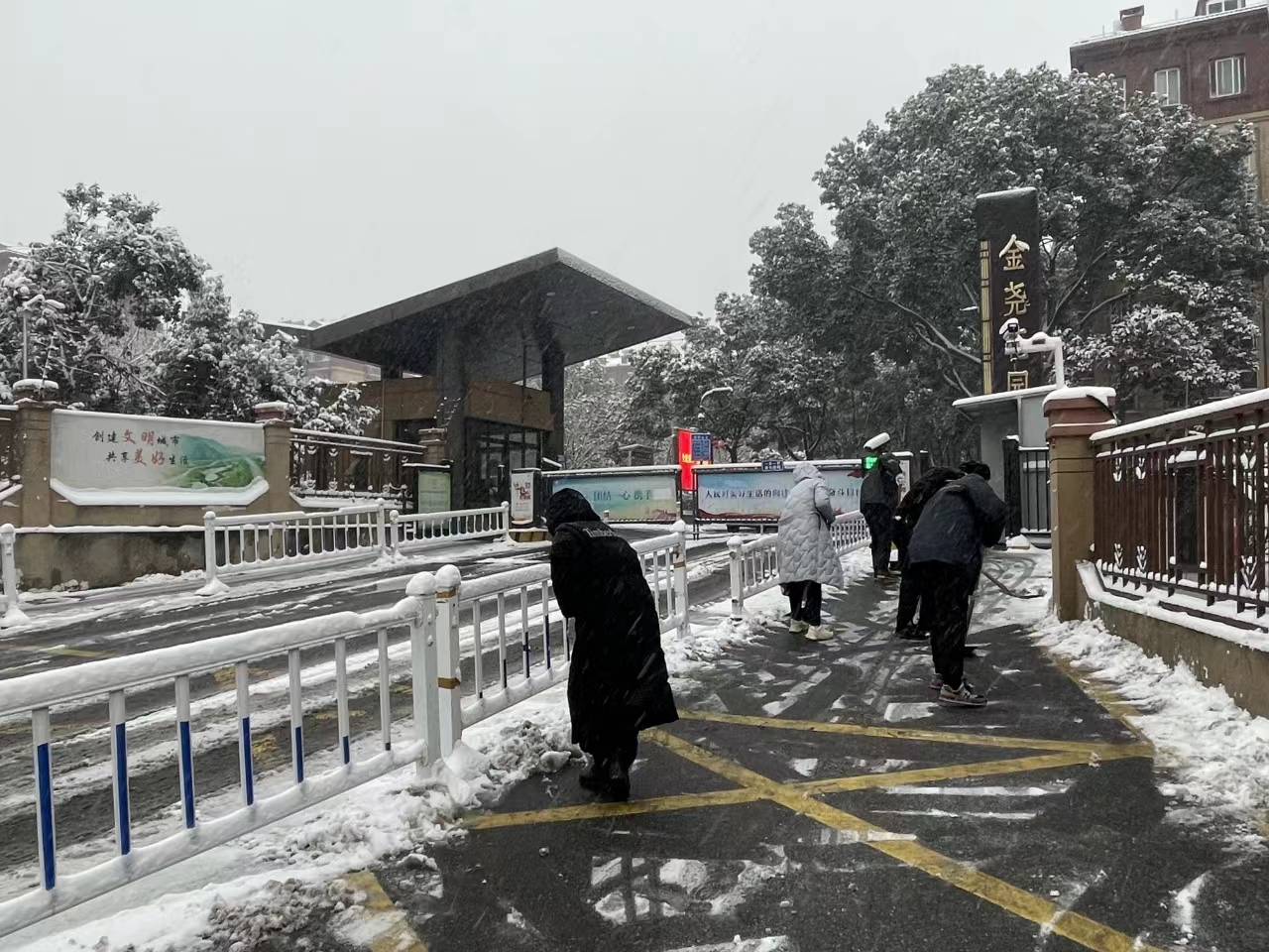 栖霞区金尧花园小区居民夏国利和家人积极参与扫雪工作,为小区居民在