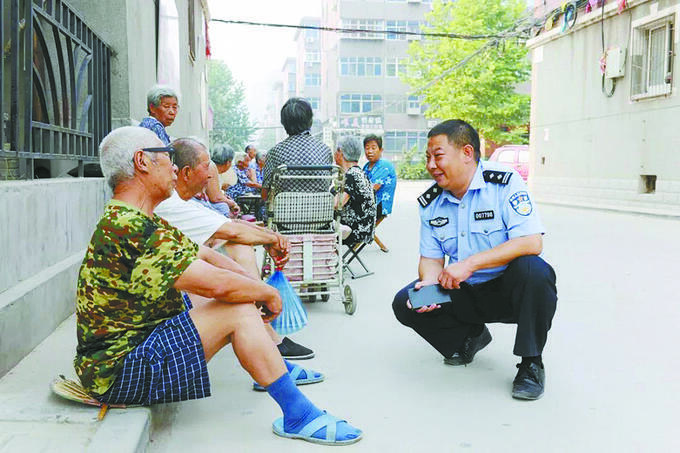 吕建江在社区走访群众。(石家庄市公安局供图)