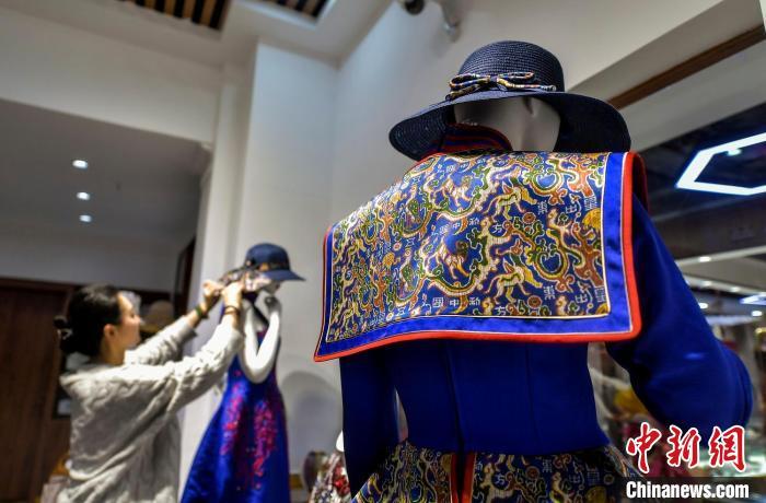 工作人员正在整理融入“五星出东方利中国”织锦护膊图案的服饰。中新网记者 刘新 摄 工作人员正在整理融入“五星出东方利中国”织锦护膊图案的服饰。中新网记者 刘新 摄