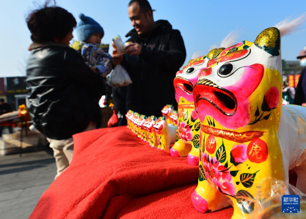1月11日，在山东省青岛市崂山区沙子口腊月年集上，市民在选购传统泥塑玩具“叫叫虎”。
进入农历腊月，春节日益临近，人们忙着购年货、写春联，红红火火迎新春。
新华社发（王海滨摄）