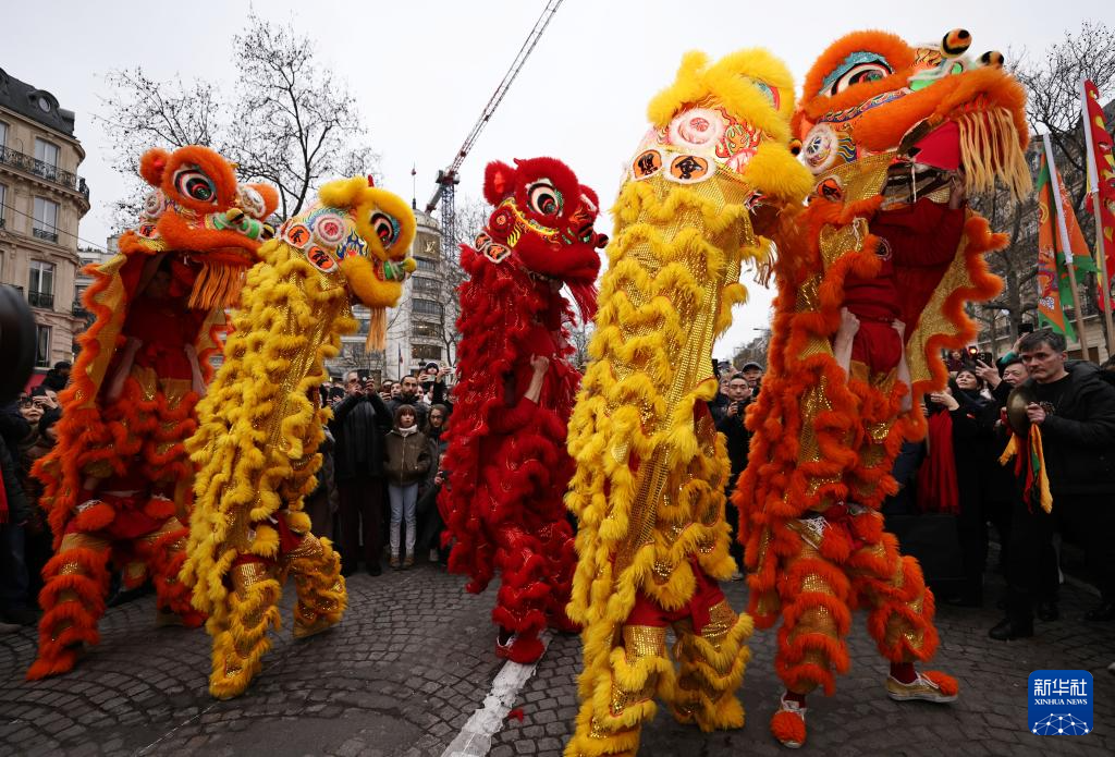 2月4日，人们在法国巴黎香榭丽舍大街观看舞龙舞狮表演。