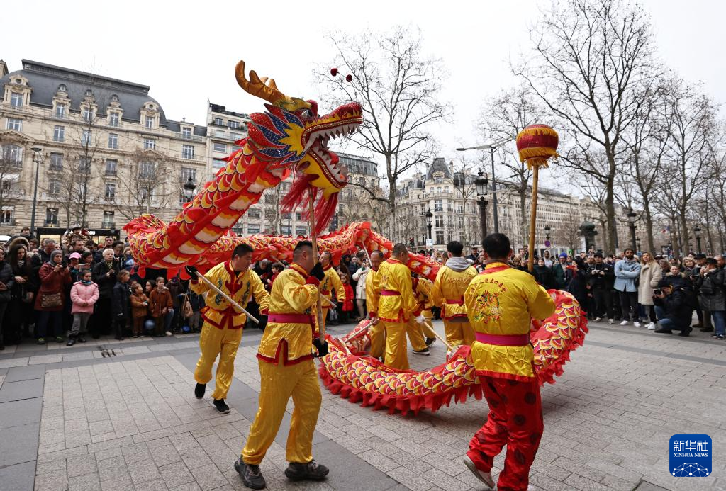 2月4日，人们在法国巴黎香榭丽舍大街观看舞龙舞狮表演。