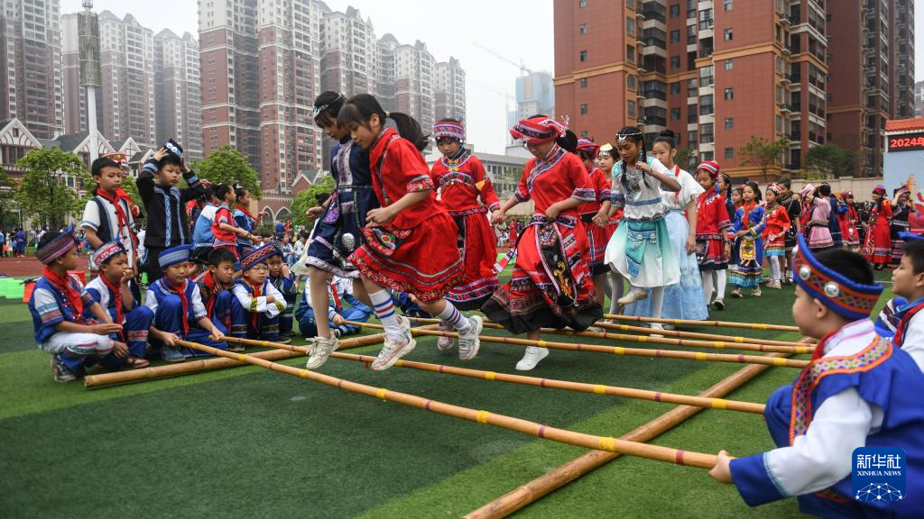 4月10日,钦州市第三十八小学的师生跳起竹竿舞,喜迎三月三
