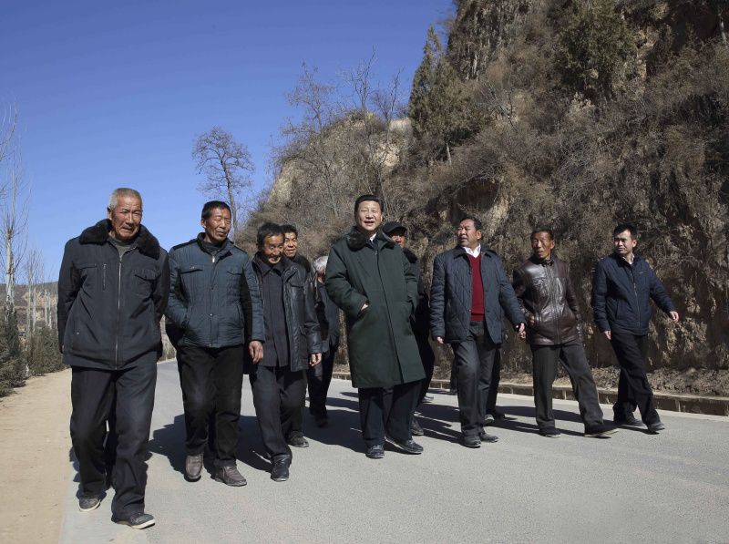 2015年2月13日上午,习近平在延安市延川县文安驿镇梁家河村调研时同村民边走边聊。新华社记者 兰红光 摄