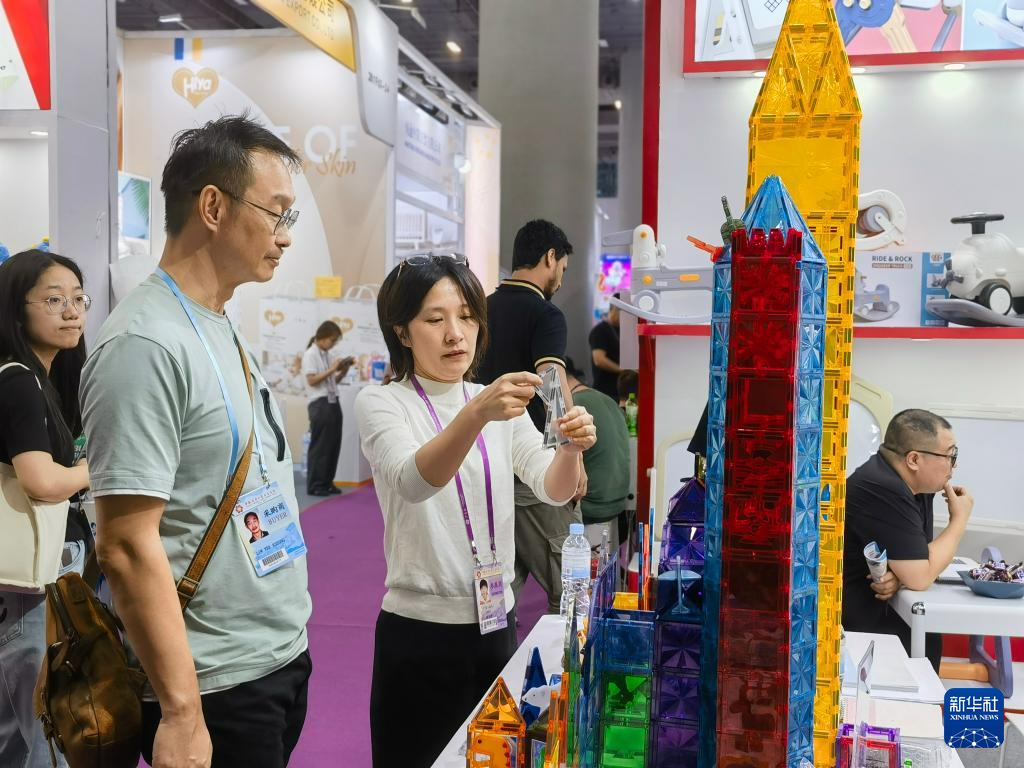 5月1日，一家玩具参展企业工作人员向客商展示产品。