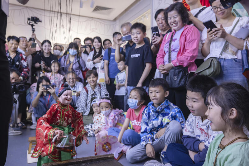 5月1日,广州市白鹅潭大湾区艺术中心非物质文化遗产馆内,精彩的梅县提线木偶戏表演吸引了众多游客驻足观赏。 来源:人民图片网