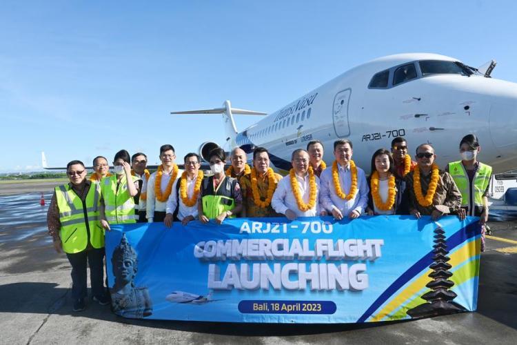 People pose for a group photo with the first jetliner ARJ21 of Indonesian airline TransNusa in Bali, Indonesia, April 18, 2023. (Commercial Aircraft Corporation of China/Handout via Xinhua)