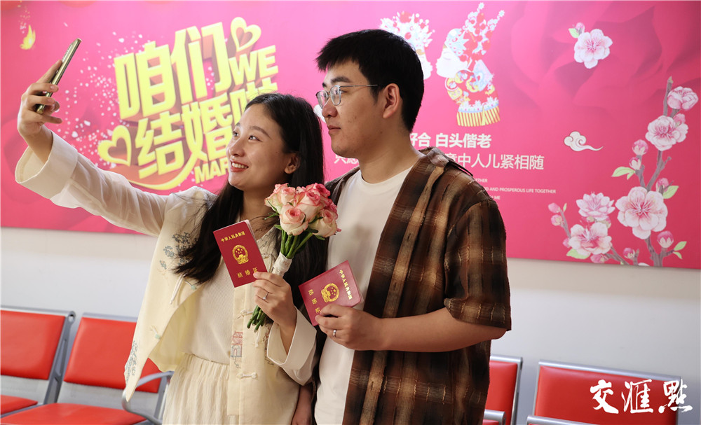 在南京市建邺区民政局婚姻登记处外,新人手持刚领取的结婚证拍照
