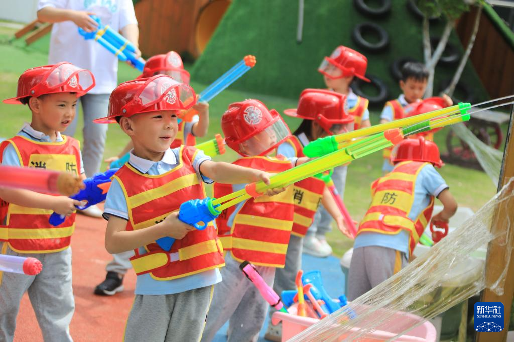 5月29日，浙江省舟山市新城翁浦幼儿园小朋友在职业体验活动中体验消防员灭火。
