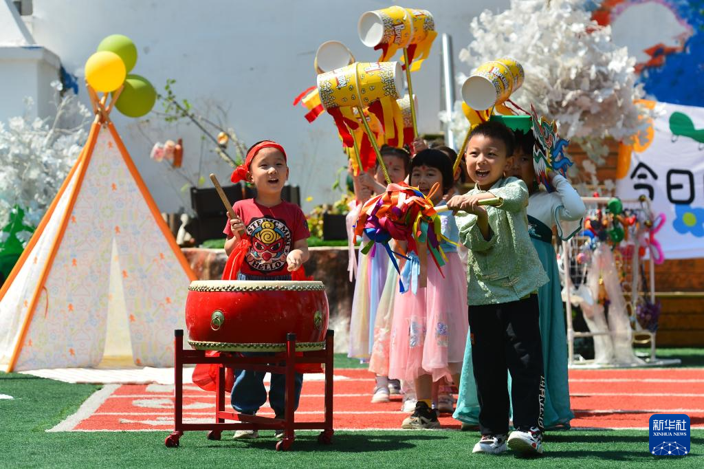 5月29日，小朋友在山东省青岛市市南区新世纪幼儿园迎“六一”活动上击鼓舞龙。
“六一”国际儿童节即将到来，各地开展丰富多彩的庆祝活动。
