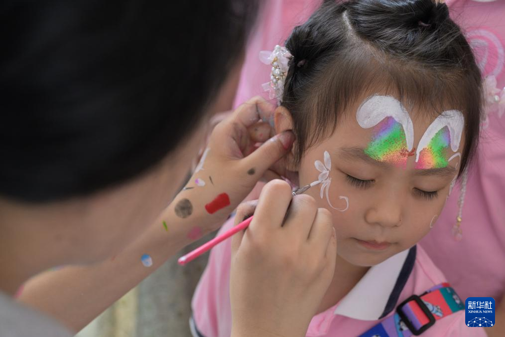 5月31日，位于武汉市洪山区的华中师范大学幼儿园组织亲子游园会、爱心义卖、画展等活动。这是小朋友在活动现场体验面部彩绘。