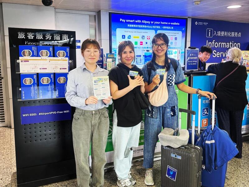 1717578709421355.jpg 5月24日,泰国游客(中、右)手持“Shanghai Pass”与工作人员合影。(图源:新华社).jpg