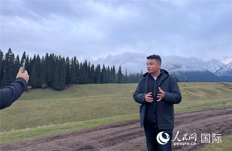 在库尔德宁,吾买尔江被雪山美景震撼,即兴录制了短视频作品。人民网记者曾书柔摄
