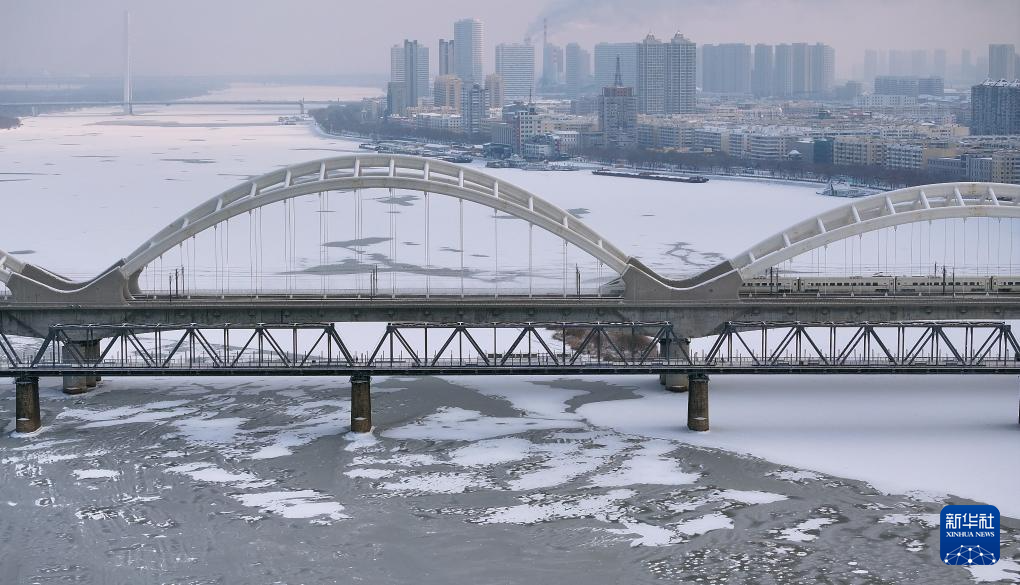 11月28日，松花江干流哈尔滨段封江，动车组列车驶过哈齐高铁松花江特大桥（无人机照片）。