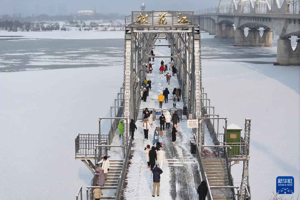 11月28日，松花江干流哈尔滨段封江，游人在滨洲铁路桥上打卡拍照（无人机照片）。