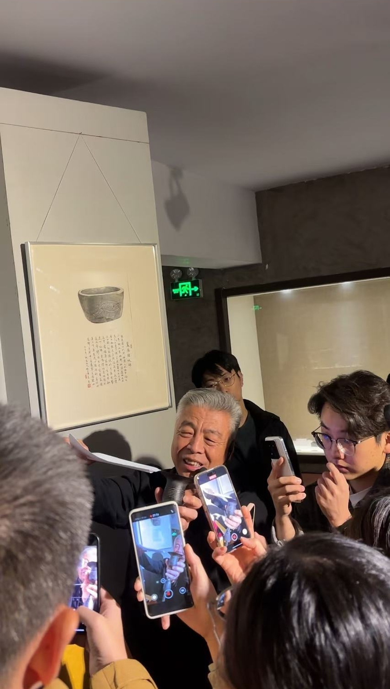 黑陶邢文化博物馆馆长邢葆东展示两张相叠的A4纸,向记者解释此为杯口的厚度。