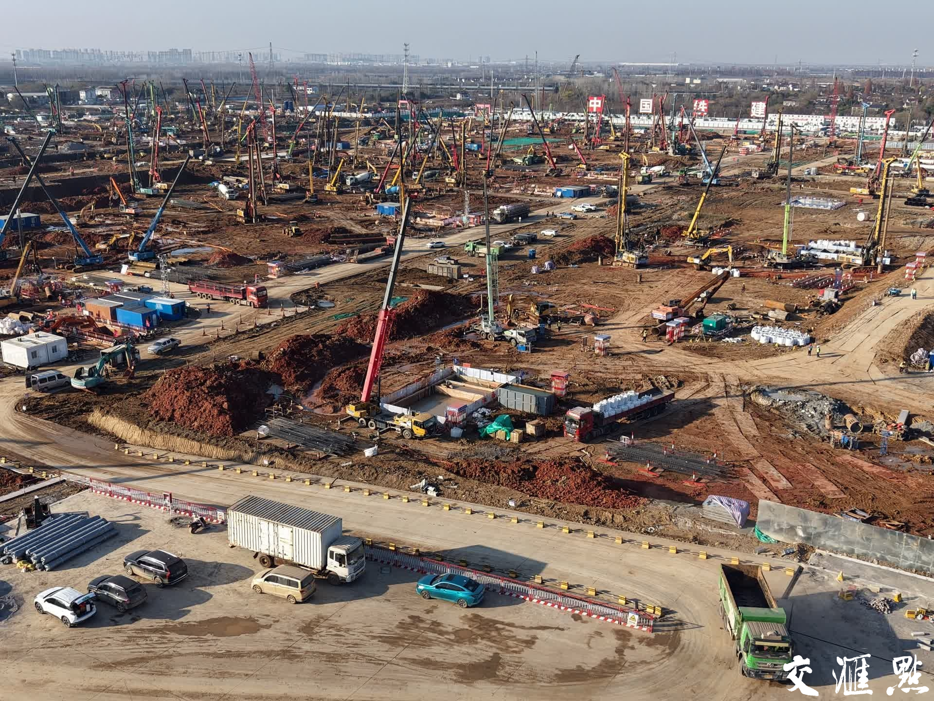 2024年12月15日，空中俯瞰南京北站施工现场，“咚咚咚——”一片繁忙的作业声，百余台机械同时打桩作业，呈现出十分壮观的建设场面。目前，作为南京江北新区的头号工程，南京北站枢纽工程正在进行打桩作业，工程建设进入实质性施工阶段。
新华日报·交汇点记者 宋宁 摄